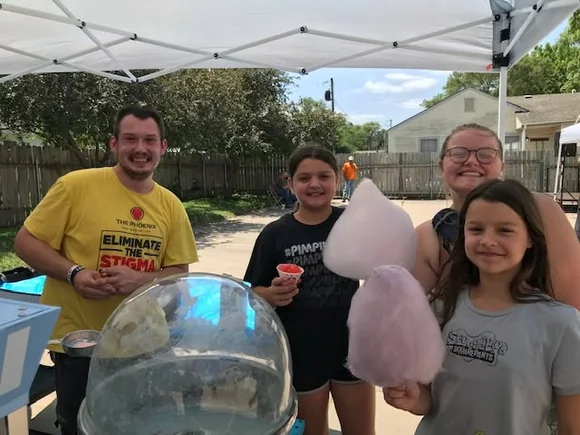 People sharing cotton candy at a Hilltop neighborhood gathering